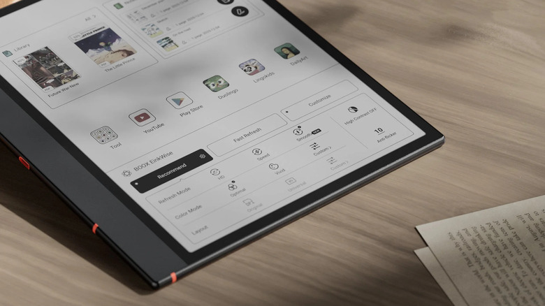 The Boox Note Air5 C tablet lying on a desk next to physical notebooks and pens.