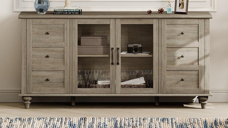 Wampat Farmhouse TV Stand featuring wood grain texture and central storage compartments.