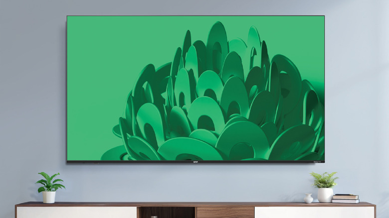 A 75-inch Onn 4K TV mounted on a modern living room wall.