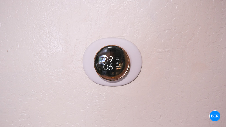 Full front view of the Nest Learning Thermostat 4th Gen sitting on a wall.