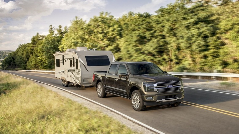 A Ford F150 SuperCrew towing an RV trailer on a scenic highway.