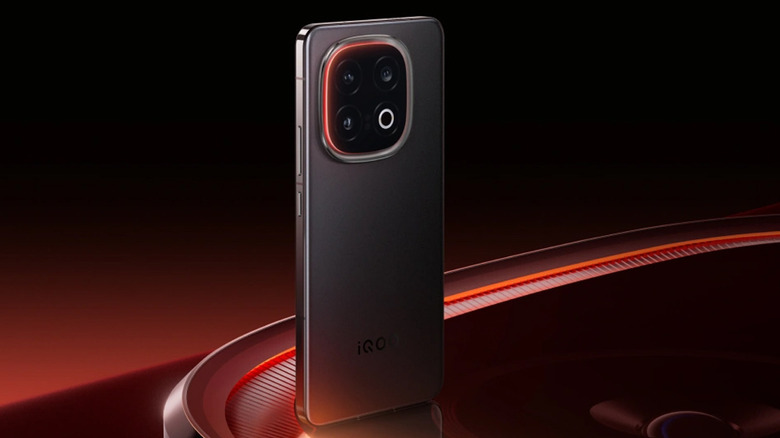 Rear view of the iQOO 13 in a sleek black finish against a red and black background.