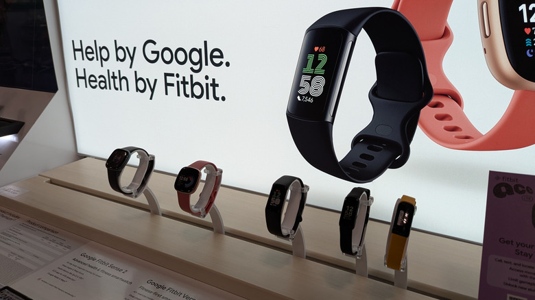 Fitbit fitness trackers and smartwatches on a retail display.