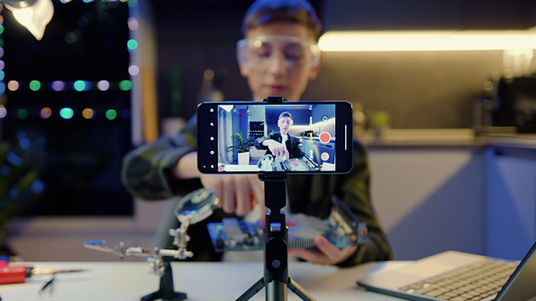 A young creator using his iPhone for high-quality live streaming and field audio recording.
