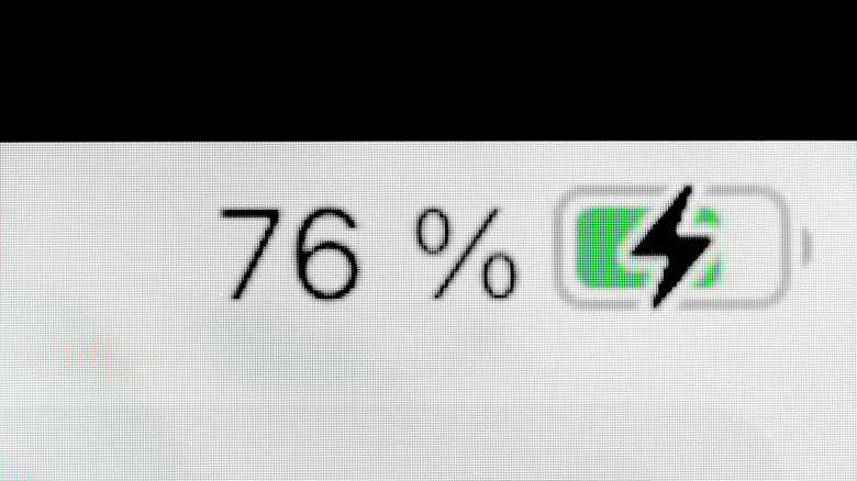 Macro view of a phone screen highlighting the battery charging symbol.