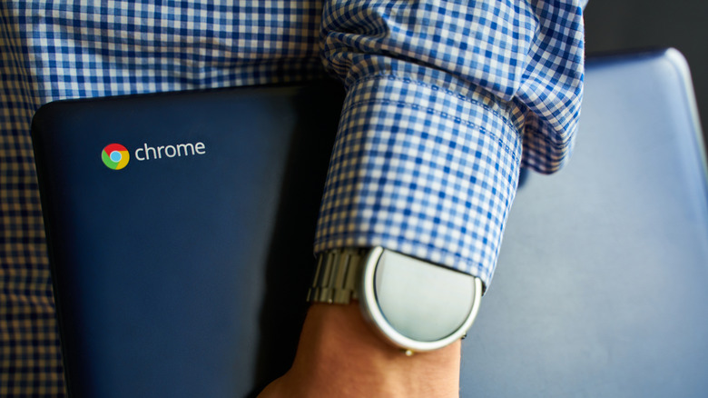 A person holding an ASUS Chromebook with both hands.
