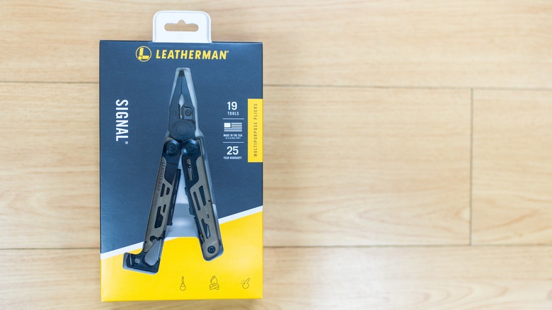 A Leatherman Signal multi-tool sitting inside its original yellow and black retail box.