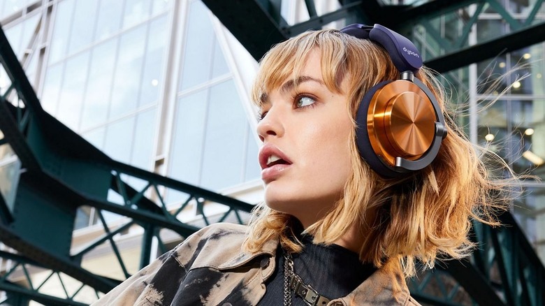 A woman wearing the distinctive Dyson OnTrac noise-cancelling headphones.