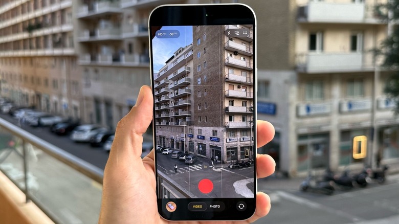 A hand holding an iPhone, showcasing its interface prepared for high-quality audio or video capture.
