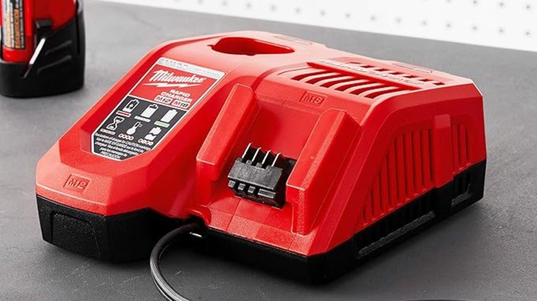 A clean, empty Milwaukee multi-voltage charger showing the electrical terminal interface.