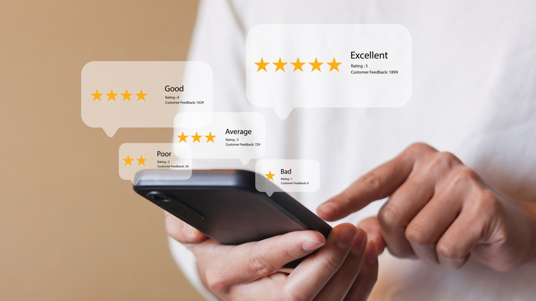 A person using a smartphone with review icons and rating concepts floating above it.