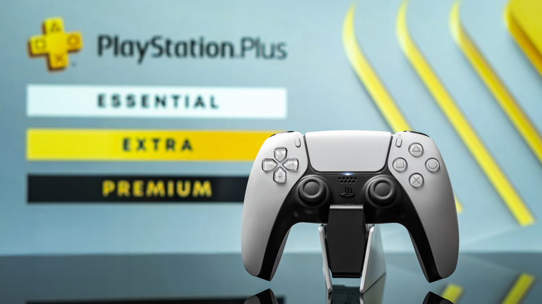 A DualSense controller with the PlayStation Plus tier selection screen in the background.
