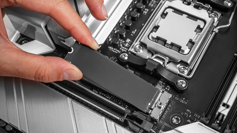 A technician installing an M.2 NVMe SSD into a motherboard slot.