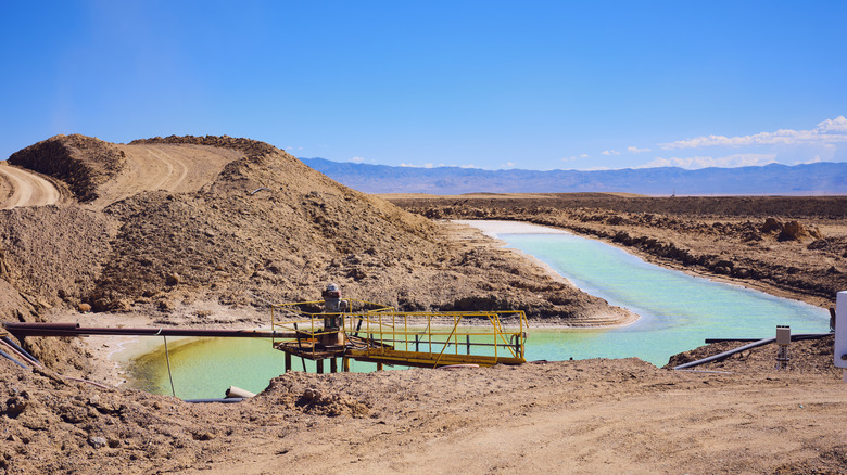 Aerial view of a vast lithium brine evaporation pond and distillation pit.