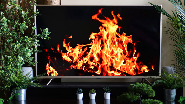 A television screen displaying a high-definition wallpaper of a fireplace.