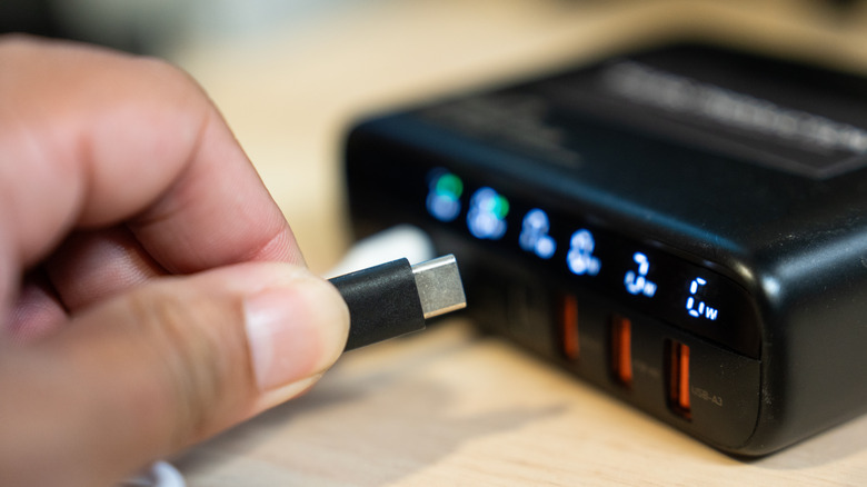 Close-up of a USB-C cable being plugged into a laptop docking station.