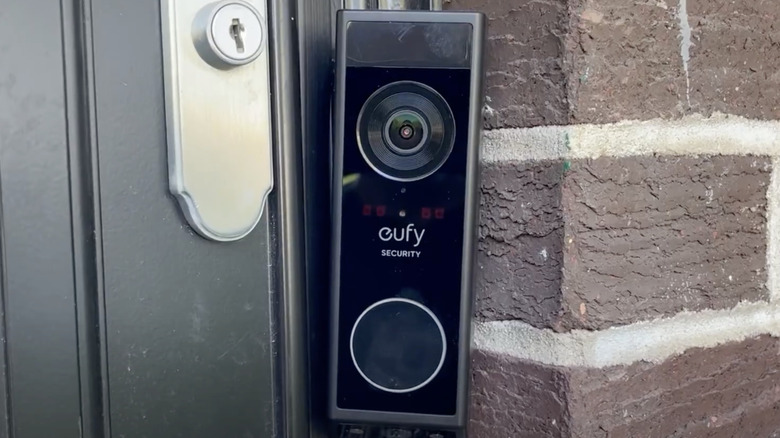 A modern smart door lock installed on a wooden door.