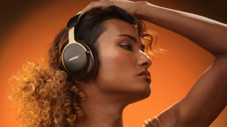 A woman wearing the Bose QuietComfort Ultra headphones in a bright setting.