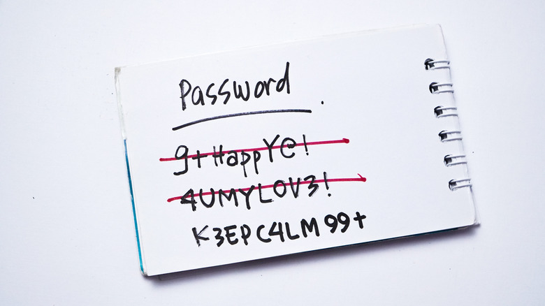 Handwritten passwords on a small notepad showing digital login details.