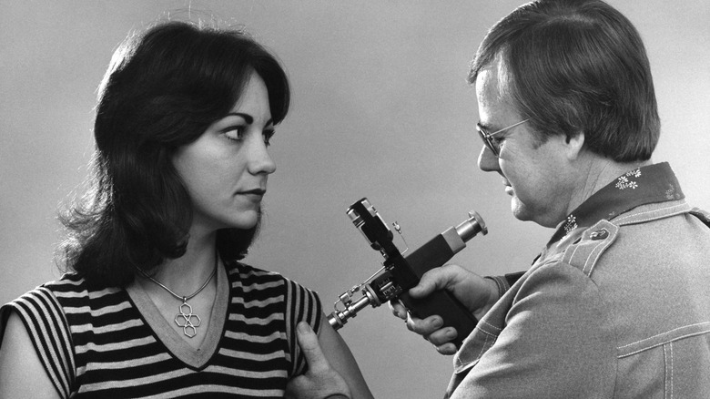 An archival photo of a vintage jet injector device used for medical injections.