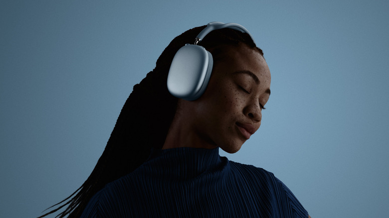 A woman wearing the silver Apple AirPods Max while looking forward.