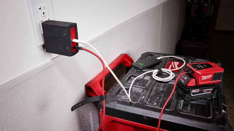 Milwaukee 120W USB-C PD Charger plugged into a standard wall outlet.