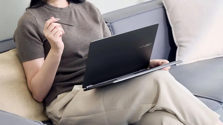 A close-up shot of the MSI Prestige 14 Flip AI+ being used on a lap with a stylus.