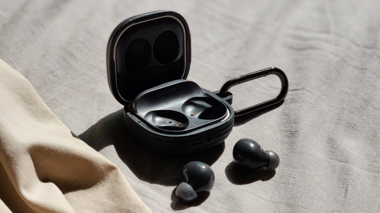 A Samsung Galaxy Buds charging case open with both earbuds displayed in the foreground.