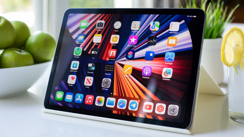 An iPad Air on a counter displaying an array of productivity and creative apps.