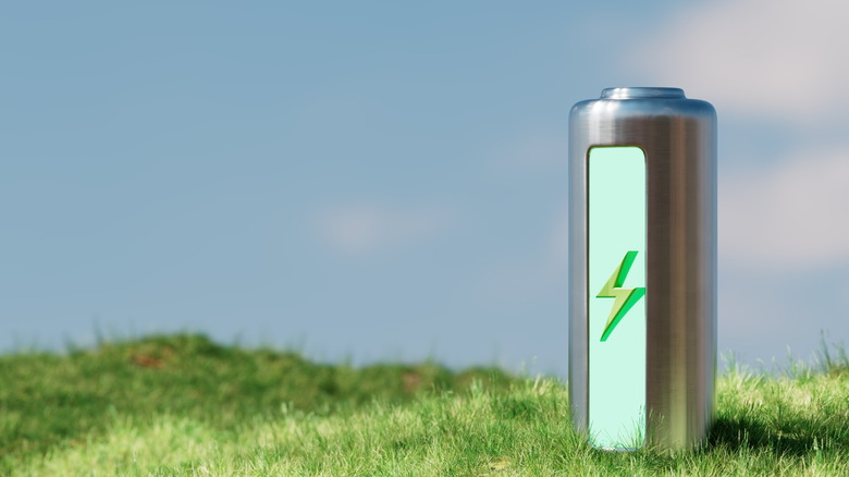 A modern battery resting on a green grassy hill representing eco-friendly energy.