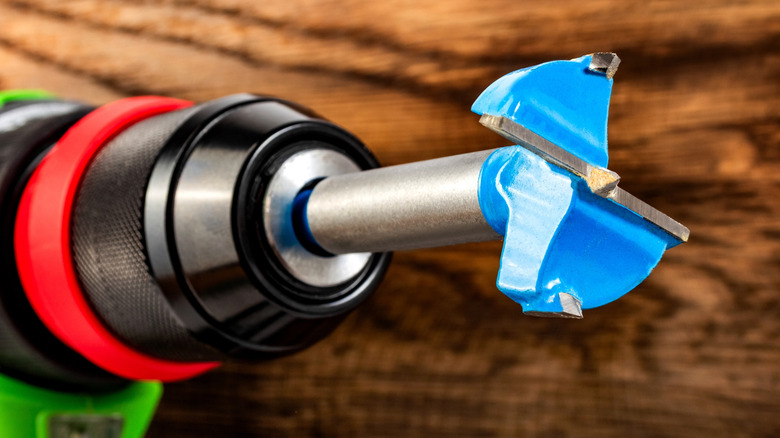 A forstner bit secured in a drill chuck.