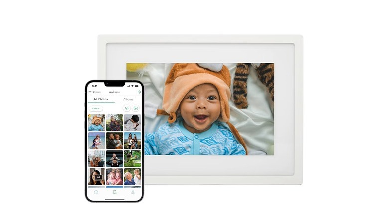 A 10-inch digital photo frame displaying a baby's picture next to a smartphone.
