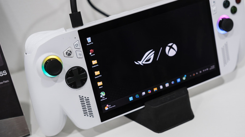 An ASUS ROG Ally handheld gaming console sitting in its charging dock on a display floor.