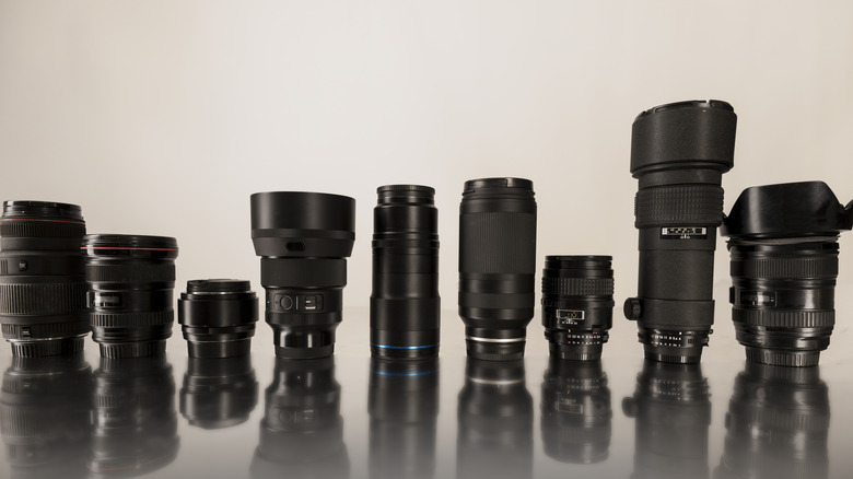 A collection of various professional camera lenses arranged on a table.