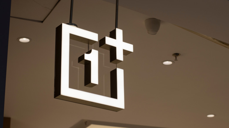 Close-up of the OnePlus logo on a physical retail store front.