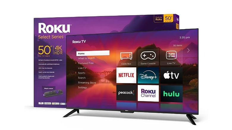 A large Roku 4K smart TV standing next to its branded retail box.