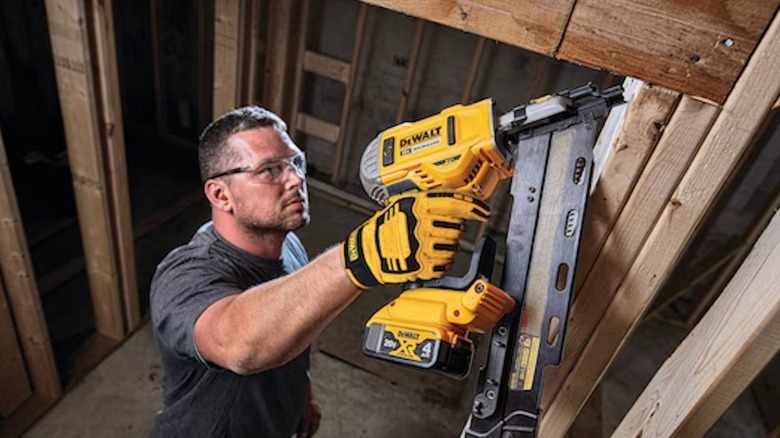 A worker wearing DeWalt performance gloves while operating a DeWalt power tool.