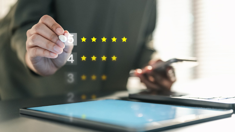 Conceptual image of a hand selecting a five-star review on a screen.