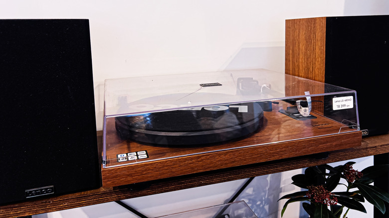 An analog turntable setup positioned between two classic stereo speakers.