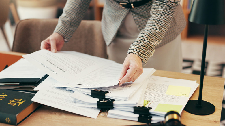 A person working with legal documents spread out on a table.