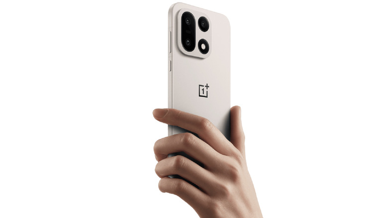 Hand holding the OnePlus 15 showing its sleek but durable build.